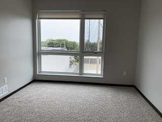 Open bedroom with large floor to ceiling window looking outside to north Lincoln