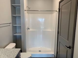 bathroom with warm brown cabinets and lots of cabinet and linen storage