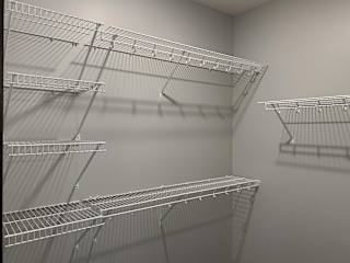 Large walk in closet with wire shelving for clothing storage