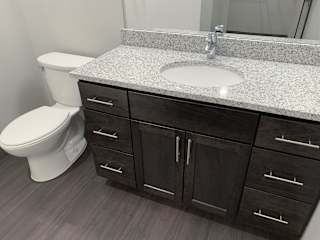Bathroom with cabinet for storage and light granite counters