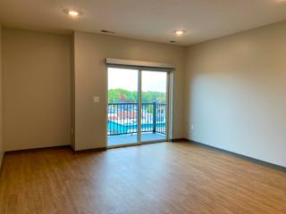 Open living room open dining room with sliding glass door to balcony at Haven at Uptown in Lincoln, Nebraska