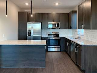 Kitchen with dark brown cabinets and large kitchen island and matching stainless steel  appliances