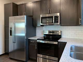 Kitchen with dark brown cabinets and large kitchen island and matching stainless steel  appliances