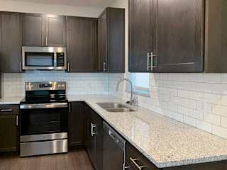 Kitchen with dark brown cabinets and large kitchen island and matching stainless steel  appliances