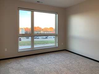 carpeted master bedroom with large floor to ceiling window