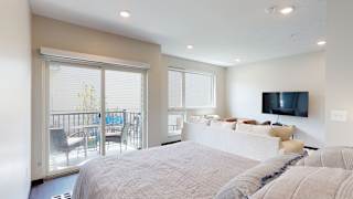 a studio apartment with a large bed and a tv on the wall