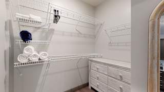 a large walk in closet with a large mirror and a dresser