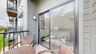 a balcony with a table and chairs and a sliding glass door