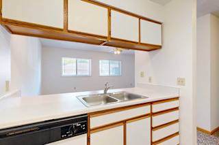 Kitchen with a passthrough window countertop and a stainless steel sink