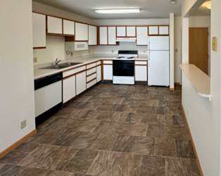a kitchen with white appliances and white cabinets with oak trim