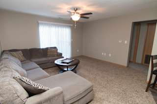 a living room with a couch and a ceiling fan