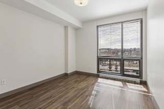 A room with a large window and wooden flooring.
