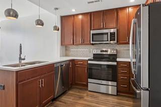 A modern kitchen with wooden cabinets and stainless steel appliances.