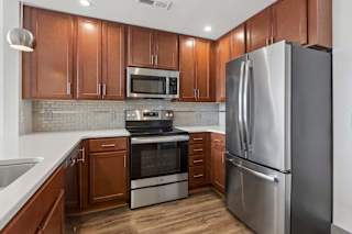 A modern kitchen with wooden cabinets and stainless steel appliances.