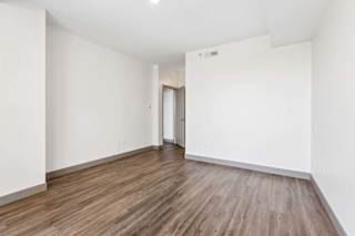 A room with wooden flooring and white walls.