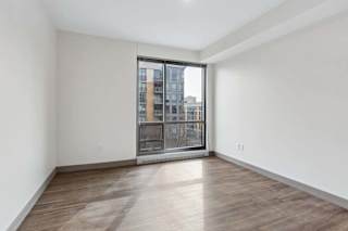 A room with a large window and wooden flooring.