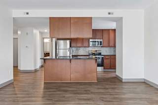 A kitchen with wooden floors and a white refrigerator.
