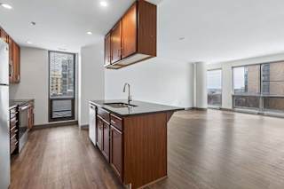 A kitchen with wooden cabinets and a black countertop.