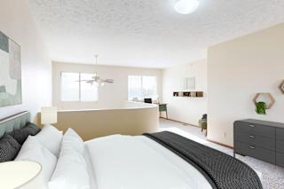 A bedroom with a large bed, a ceiling fan, and large windows