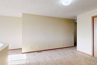 A carpeted loft bedroom with a view open to below and a sliding double-door closet.
