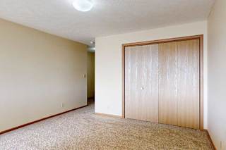 A carpeted loft bedroom with a sliding double-door closet.