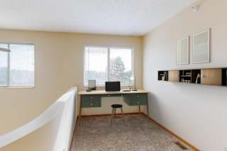 A room with a desk and a chair in it.