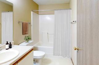 A bathroom with a toilet, sink, and bathtub.