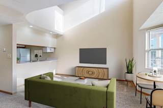 A modern living room with a green sofa and a television.
