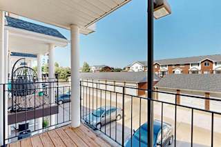 A balcony with a metal railing and a view of neighboring apartments.
