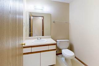 A bathroom with a vanity sink, mirror, and towel rack.