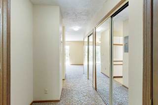 A hallway to the kitchen and living area, with two sliding mirror door closets on the right.