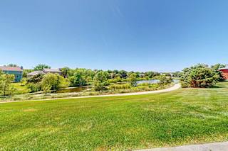 A view from the patio area of the surrounding green space and neighboring pond.