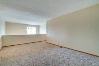 A room with a carpeted floor and a window.