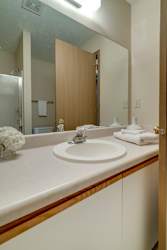 A bathroom with a sink, mirror, and towel.
