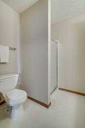 A white toilet with a towel hanging on the wall.