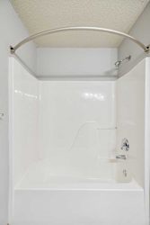 A white bathroom with a tub and shower.