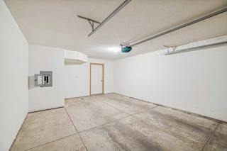 A room with a concrete floor and a door on the right side.