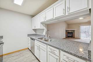 A kitchen with granite countertops and white cabinets.