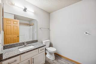 A bathroom with a toilet, sink, and mirror.