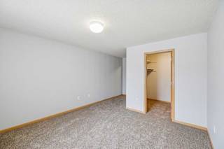 A room with a carpeted floor and a doorway leading to another room.