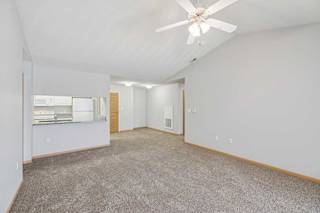 A spacious room with a ceiling fan and carpeted floor.