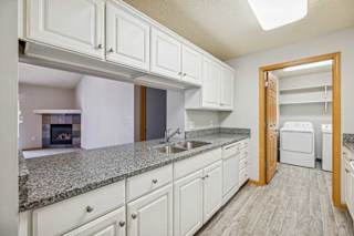 A kitchen with white cabinets and a granite countertop.