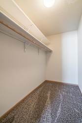 A room with a carpeted floor and a white wall.