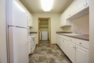 A kitchen with white appliances and cabinets.