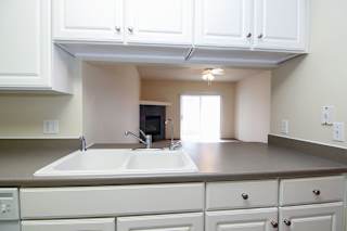 A kitchen with white cabinets and a sink.