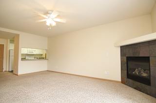 A living room with a fireplace and a ceiling fan.