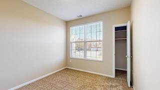 a bedroom with a large double window and a closet
