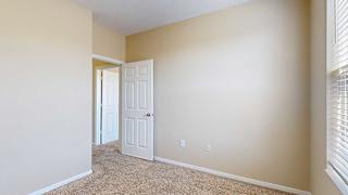 a bedroom with a large window and a carpeted floor