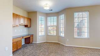 a living room with a bay window and built-in desk, providing a bright and functional workspace
