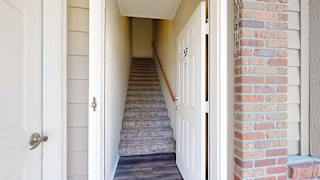 a private entryway with a staircase leading to the upper level next to a door to the private attached garage